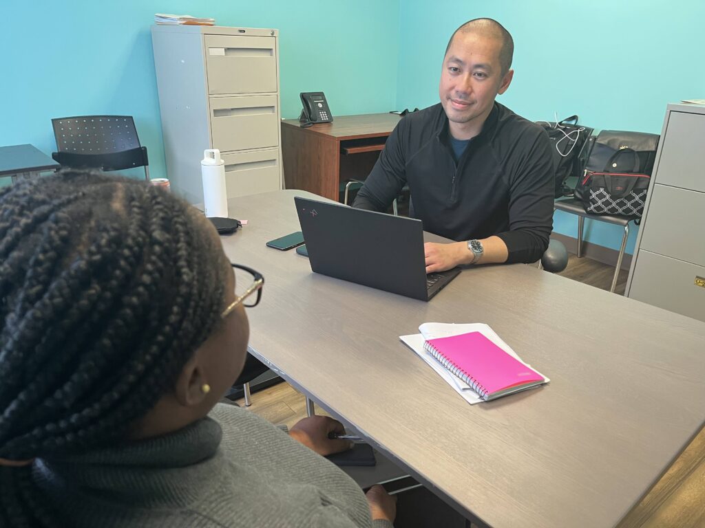 Man sitting on a table with a computer.