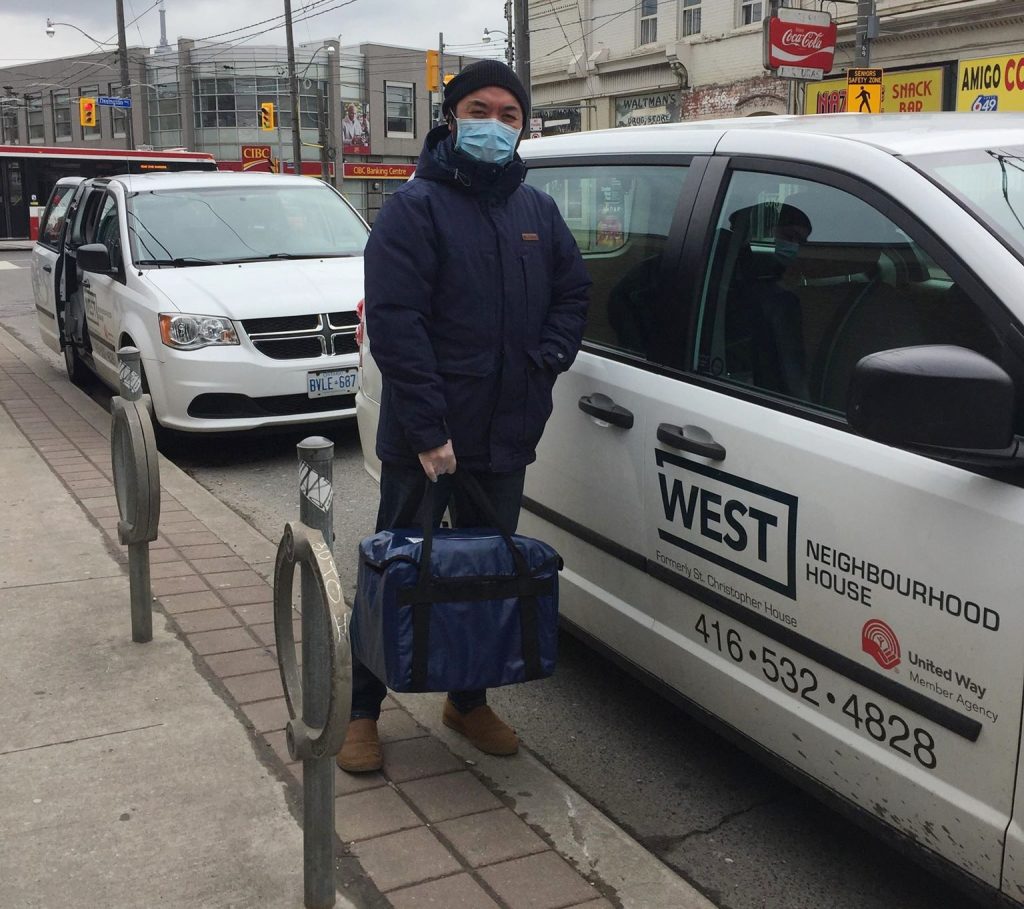 staff member delivers meals on wheels using PPE