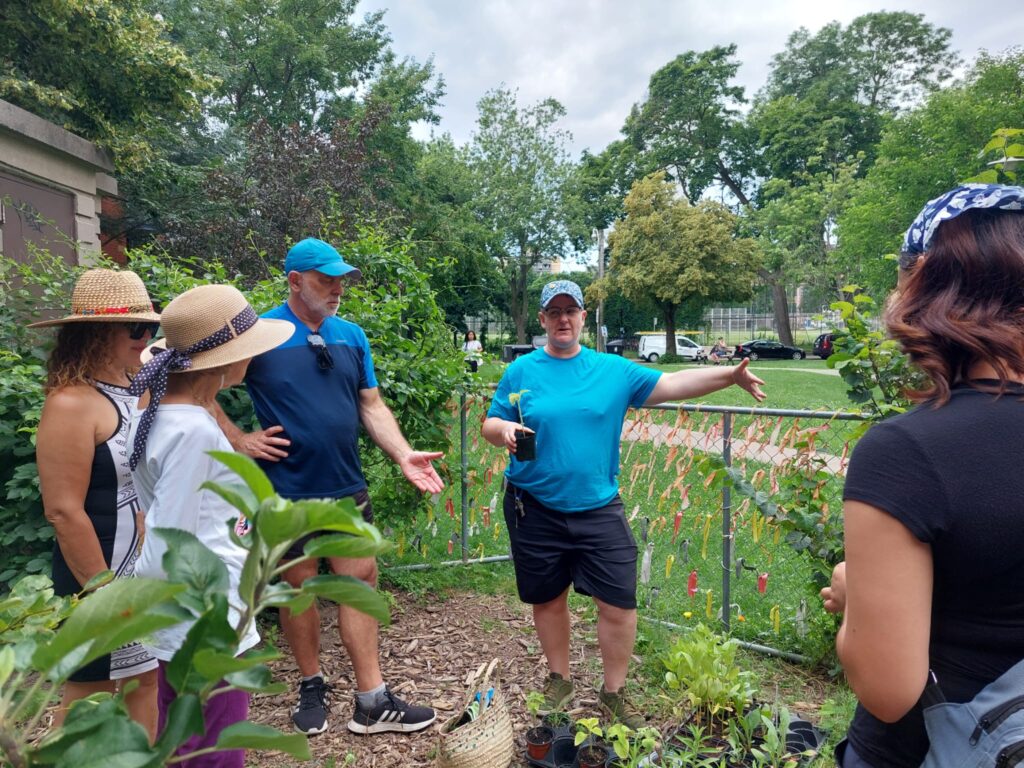 Group of people in a garden. One is giving a lesson.
