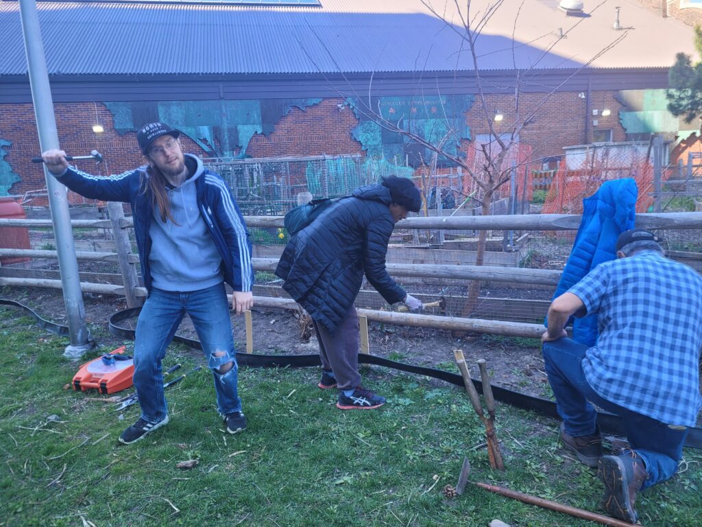 Three people building a fence